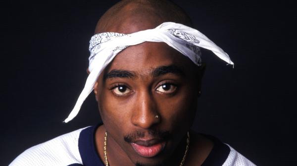 Free 2pac tupac shakur is wearing white t shirt having nose pin in blue background hd music wallpaper download