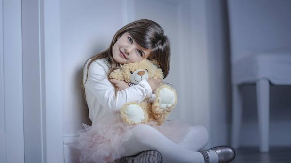 Free ash eyes cute little girl is hugging teddy toy wearing white dress in white background hd cute wallpaper download