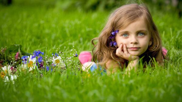 Free ash eyes cute little girl is lying down on green grass holding face with one hand hd cute wallpaper download