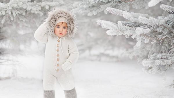 Free ash eyes cute little girl is standing on snow wearing white knitted woolen cap and dress in snow field background hd cute wallpaper download