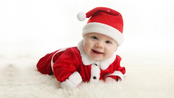 Free baby wearing santa claus dress while taking photo lying on white mat hd cute wallpaper download