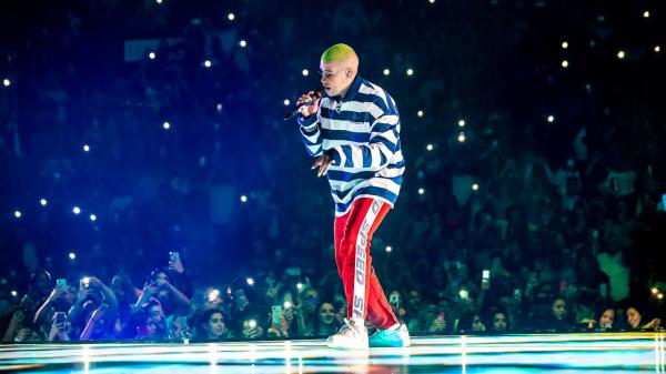 Free bad bunny aesthetic is singing in front of fans wearing striped tshirt and red track pants hd music wallpaper download