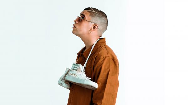 Free bad bunny aesthetic with hanging shoes on neck looking up wearing brown coat in white background hd music wallpaper download