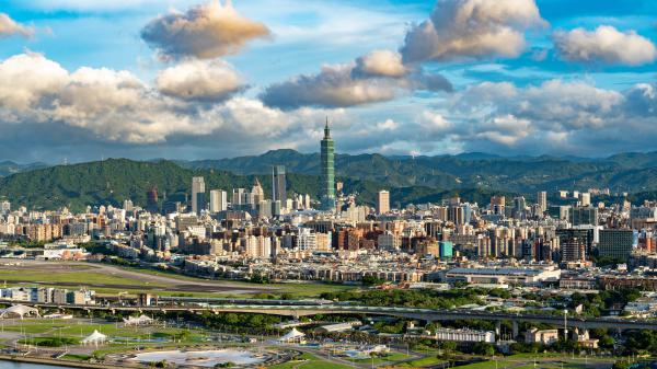 Free beautiful buildings under white clouds and blue sky with background of green covered mountains 4k 8k hd travel wallpaper download