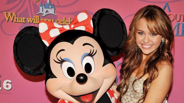 Free blonde hair miley cyrus is standing near mickey mouse hd miley cyrus wallpaper download