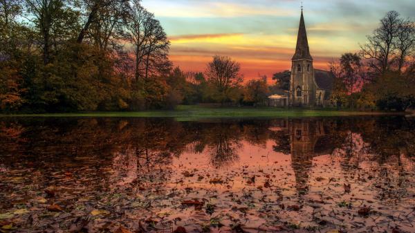 Free church surrounded by green trees with reflection on lake during sunset 4k hd travel wallpaper download