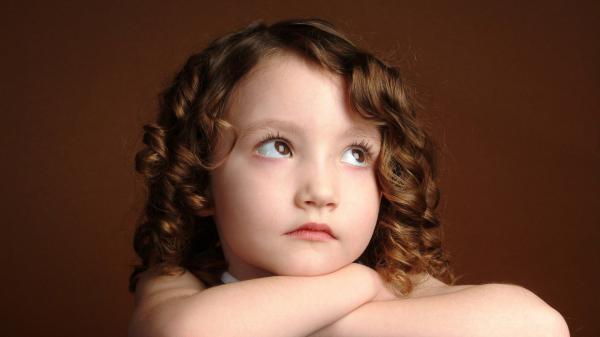 Free cute baby girl is looking up with sad face in brown background hd cute wallpaper download