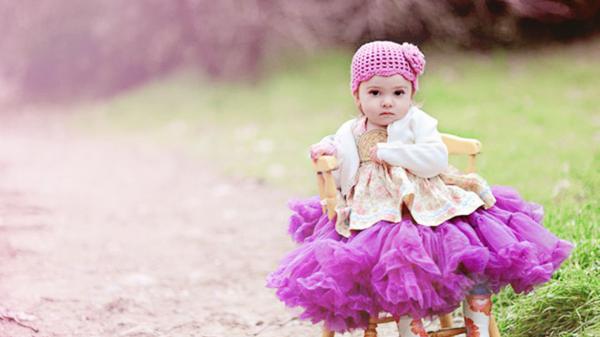 Free cute baby girl is sitting on chair in blur background wearing purple dress and woolen knit cap hd cute wallpaper download