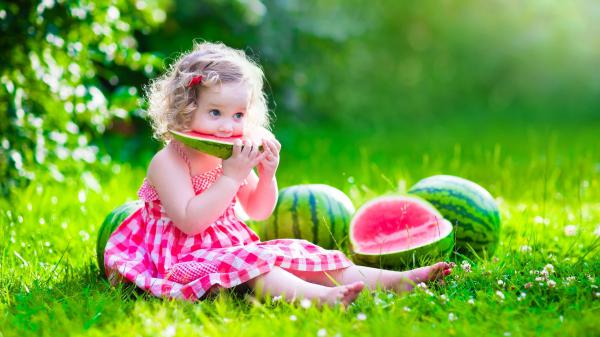 Free cute baby girl is sitting on green grass eating watermelon wearing pink dress 4k hd cute wallpaper download