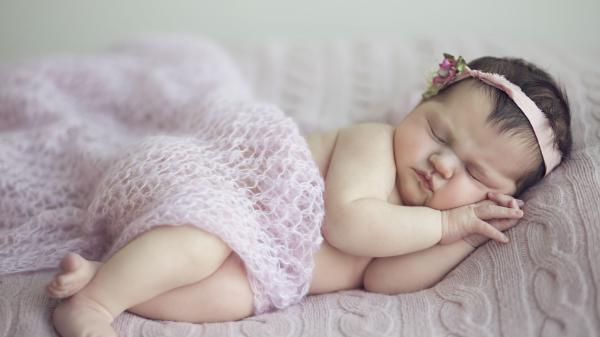 Free cute baby girl is sleeping on bed covered with netted cloth and having band on head hd cute wallpaper download