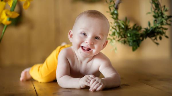 Free cute baby is lying down on floor with smiley face wearing yellow pant hd cute wallpaper download