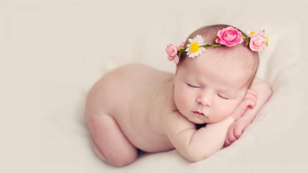 Free cute baby is sleeping on hands in bed having flowers crown on head hd cute wallpaper download