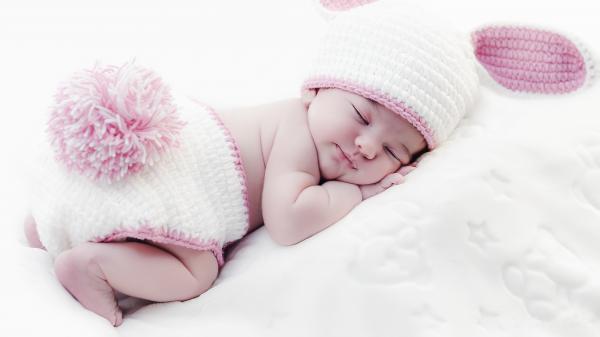 Free cute baby is sleeping on white bed wearing white bunny woolen netted cap and underwear 4k hd cute wallpaper download