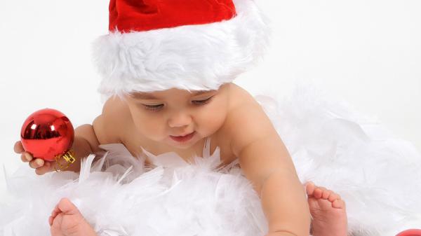 Free cute baby is wearing santa claus cap having christmas decoration red ball in hand hd cute wallpaper download