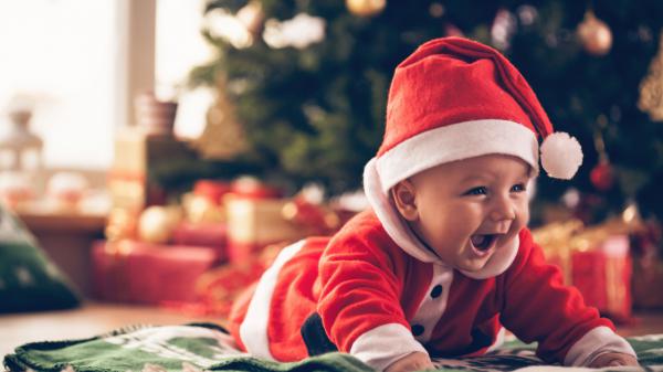 Free cute baby is wearing santa outfit lying down on mat in a blur background 4k hd cute wallpaper download
