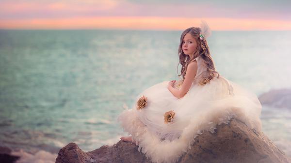 Free cute little girl is sitting on sand rock wearing white dress hd cute wallpaper download