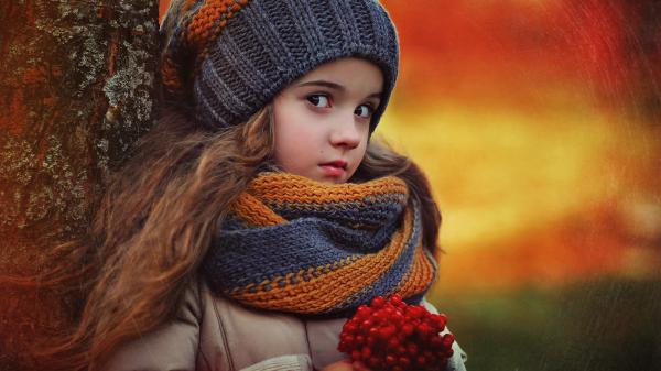 Free cute little girl is wearing blue orange woolen knitted muffler and cap in blur red yellow background hd cute wallpaper download