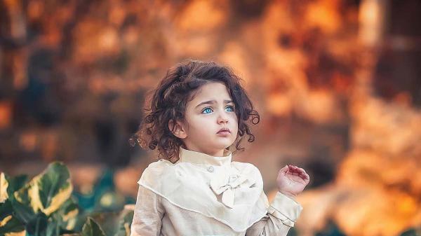 Free cute little girl is wearing sandal color top looking up in blur background hd cute wallpaper download