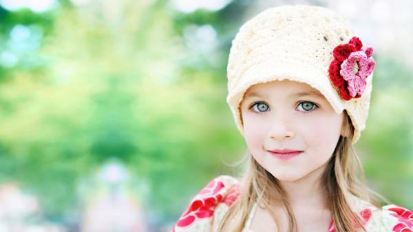 Free cute little girl is wearing yellow and red dress and wool knitted cap on head standing in blur background hd cute wallpaper download