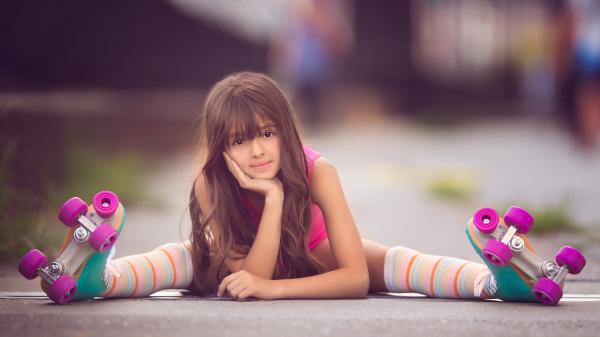 Free cute little girl skater is sitting on road holding face in hand in a blur background 4k hd cute wallpaper download