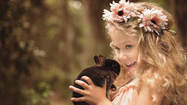 Free cute smiley girl baby is having flower crown on head and having black rabbit in hand hd cute wallpaper download