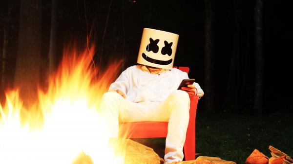 Free dj marshmello is sitting in front of fire wearing white dress with phone in hand 4k 5k hd marshmello wallpaper download