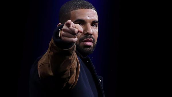 Free drake is pointing wearing brown blue jacket in black blue background hd drake wallpaper download