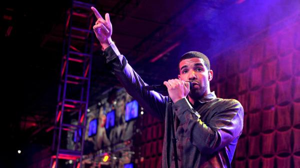 Free drake is raising right hand up in purple background having mike in hand hd drake wallpaper download