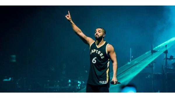 Free drake is raising right hand up wearing green t shirt in blue background 4k hd drake wallpaper download