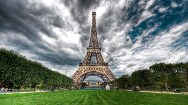 Free eiffel tower with green grass field on front with background of clouds hd travel wallpaper download