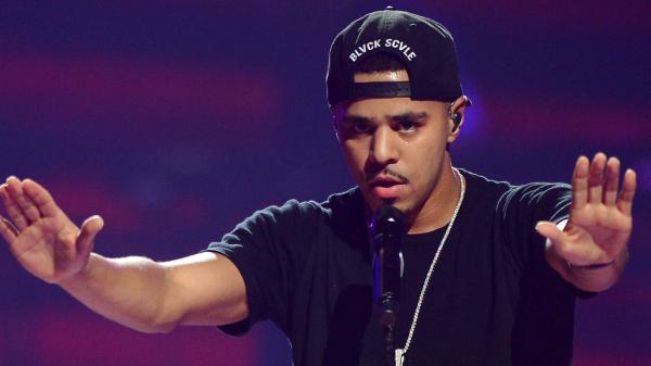 Free j cole in purple background wearing black t shirt and cap hd music wallpaper download