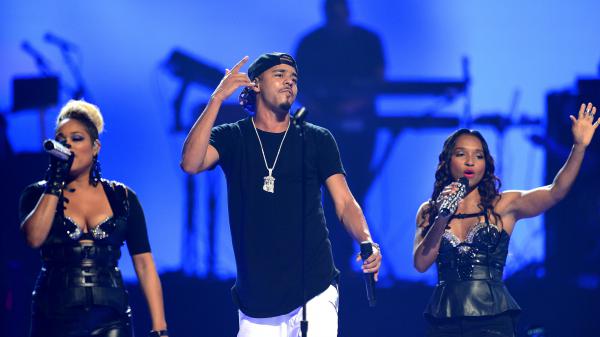 Free j cole is performing on stage with girls in blue background wearing black t shirt and white pants 4k hd music wallpaper download