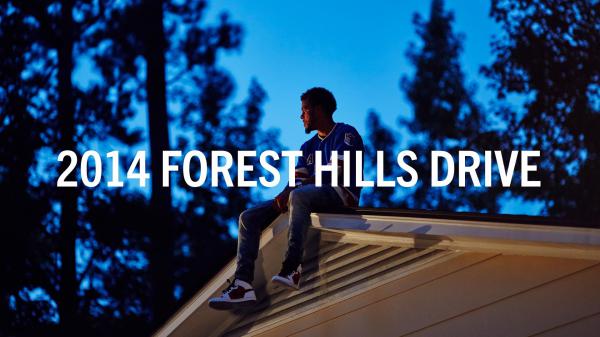 Free j cole is sitting on roof top wearing blue t shirt in blue trees background hd music wallpaper download