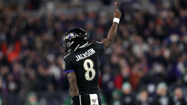 Free lamar jackson is wearing black dress and helmet having one hand in the air with audience background hd sports wallpaper download