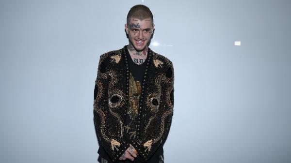 Free lil peep is standing in light ash background wearing black tshirt and coat having tattoos on face and neck hd music wallpaper download