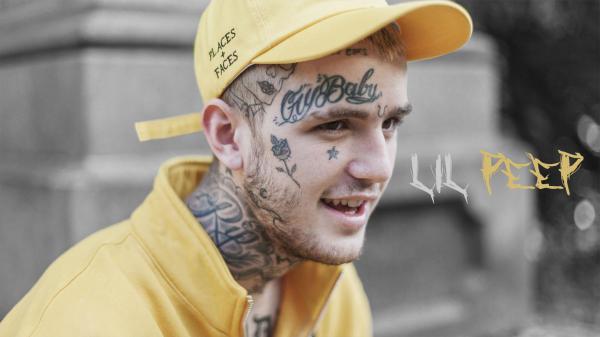 Free lil peep is wearing yellow dress and cap having tattoos on face and neck in blur background hd music wallpaper download