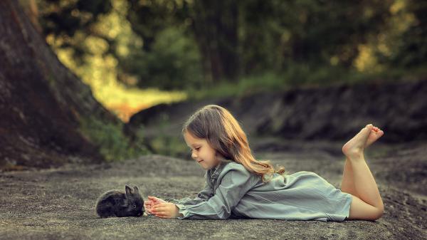 Free little girl is lying down on a road and playing with rabbit 4k hd cute wallpaper download