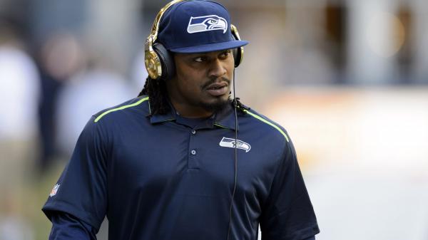 Free marshawn lynch is wearing blue sports dress and cap with headset hd seattle seahawks wallpaper download
