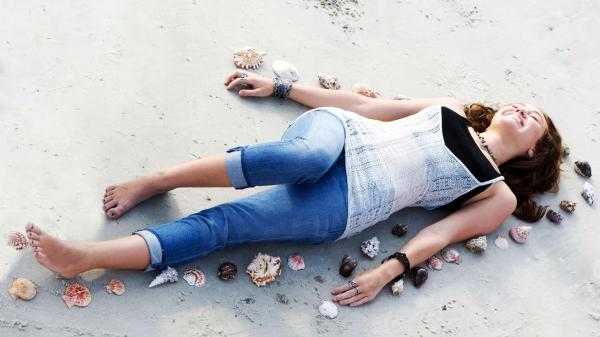 Free miley cyrus is lying on beach sand hd miley cyrus wallpaper download