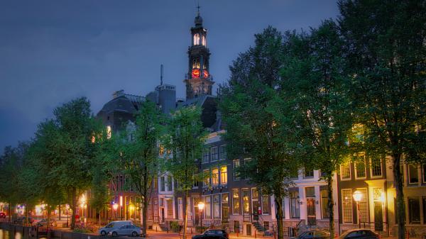 Free netherlands amsterdam canal city cars and clock tower between house during evening 4k 5k hd travel wallpaper download