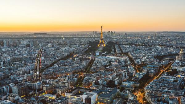 Free paris eiffel tower and cityscape with yellow and gray sky background during sunset hd travel wallpaper download