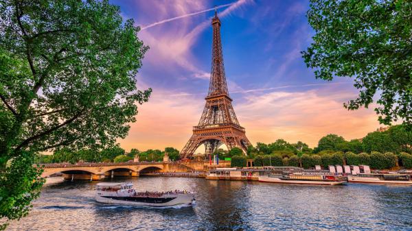 Free paris eiffel tower and trees on sides and lake and boats on front with background of blue sky and purple clouds hd travel wallpaper download