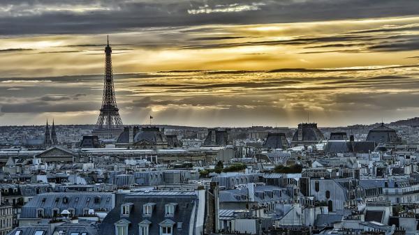 Free paris eiffel tower around gray cityscape with yellow and gray background of sunbeam and clouds hd travel wallpaper download