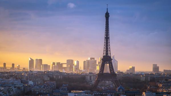 Free paris eiffel tower with background of taller buildings and cloudy sky hd travel wallpaper download