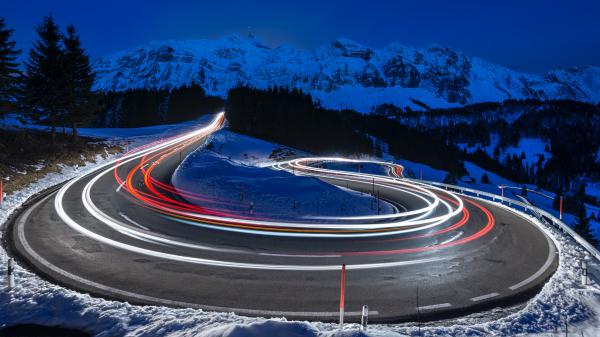 Free photography of curved lighting road surrounded snow covered mountains 4k 5k hd wallpaper download