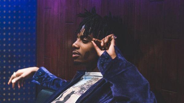 Free playboi carti is sitting on couch wearing blue coat having cigar in hand hd music wallpaper download