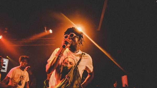 Free playboi carti is wearing girl printed white tshirt having mike in hand in light background hd music wallpaper download