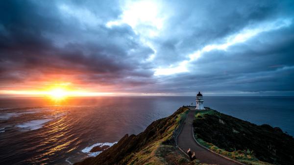 Free road heading to lighthouse under blue sky pacific ocean during sunset hd travel wallpaper download