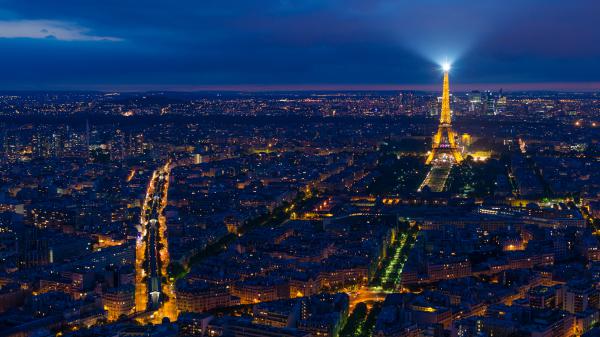 Free shimmering paris city and eiffel tower with white light on top with gray cloudy sky background 4k 5k hd travel wallpaper download