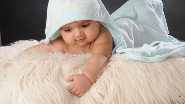 Free smiley cute baby boy is lying down on woolen bed covered with head towel 4k hd cute wallpaper download